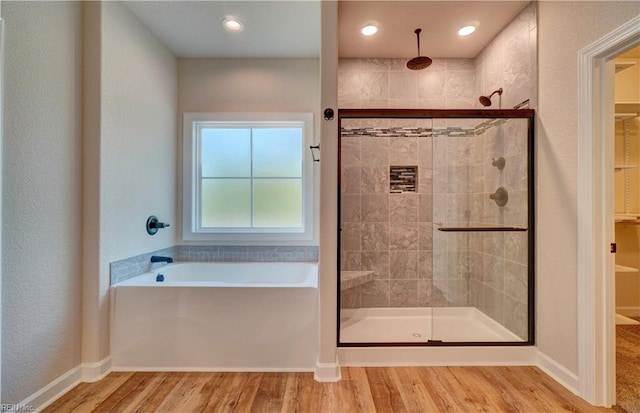 bathroom featuring wood-type flooring and plus walk in shower