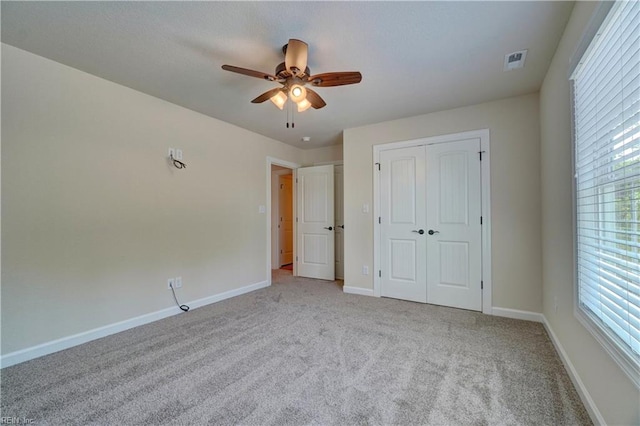 unfurnished bedroom with a closet, ceiling fan, and light colored carpet