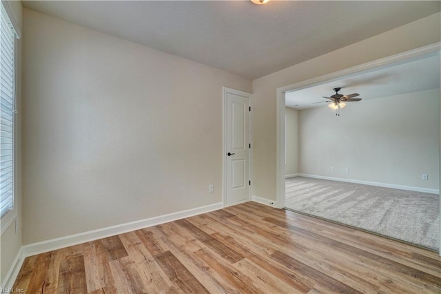 spare room with light wood-type flooring and ceiling fan