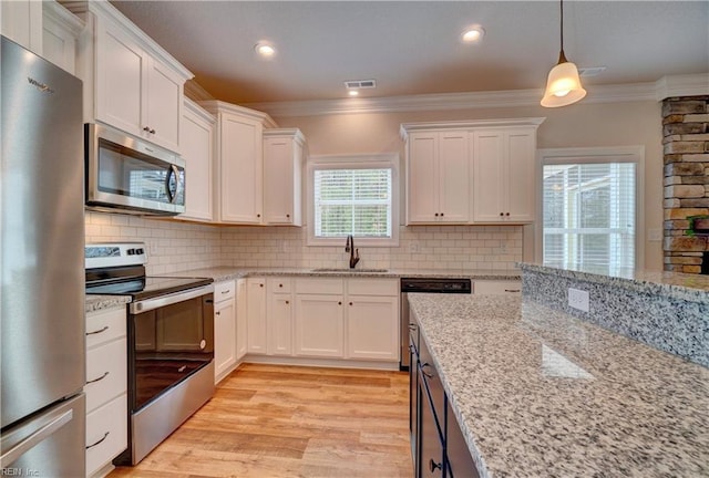 kitchen with light hardwood / wood-style flooring, white cabinets, appliances with stainless steel finishes, and sink