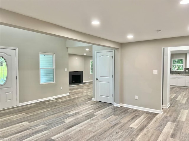 unfurnished living room with light wood-type flooring and sink