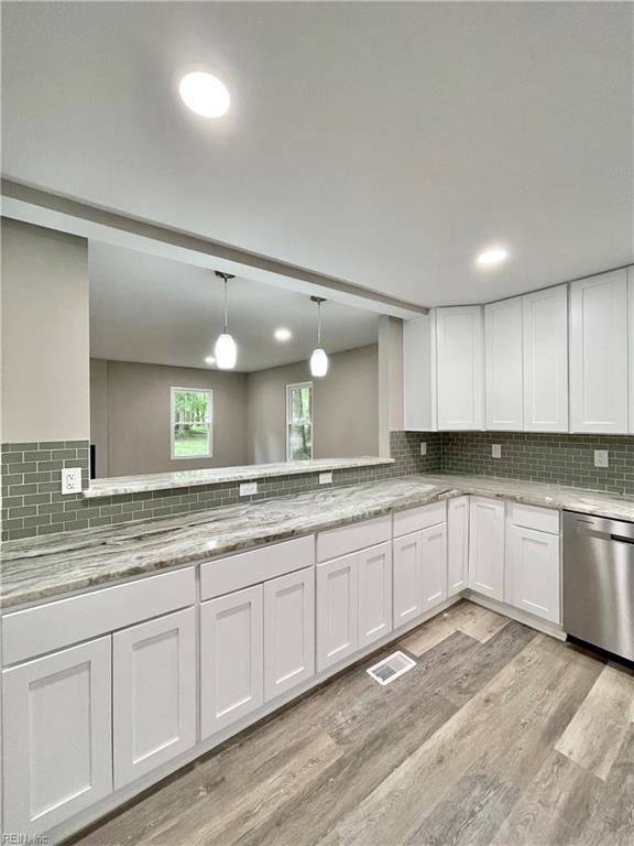 kitchen featuring pendant lighting, dishwasher, light hardwood / wood-style floors, white cabinetry, and decorative backsplash