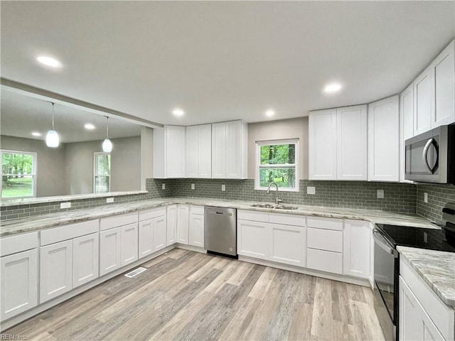 kitchen featuring light hardwood / wood-style floors, white cabinetry, sink, and stainless steel appliances