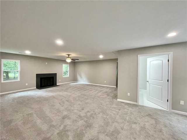 unfurnished living room featuring ceiling fan and light colored carpet