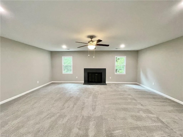 unfurnished living room with ceiling fan and light carpet