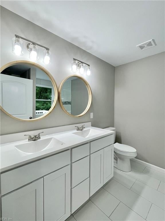 bathroom featuring tile patterned flooring, vanity, and toilet