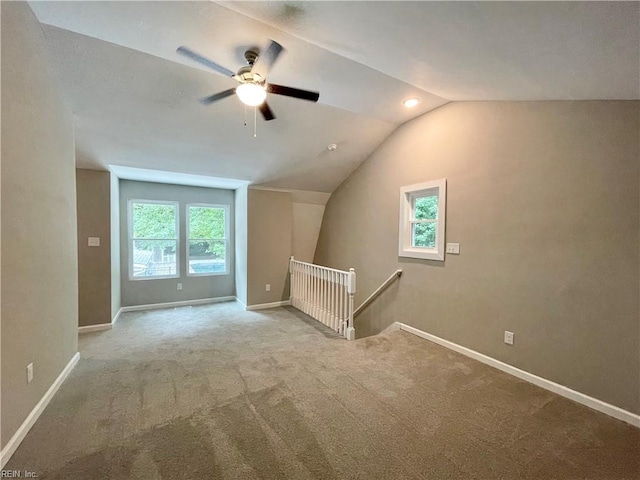 bonus room featuring a wealth of natural light, lofted ceiling, ceiling fan, and light colored carpet