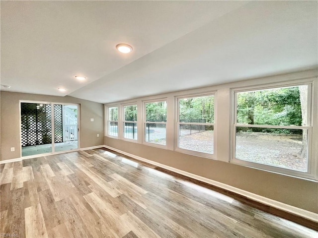 unfurnished living room with light hardwood / wood-style flooring and vaulted ceiling