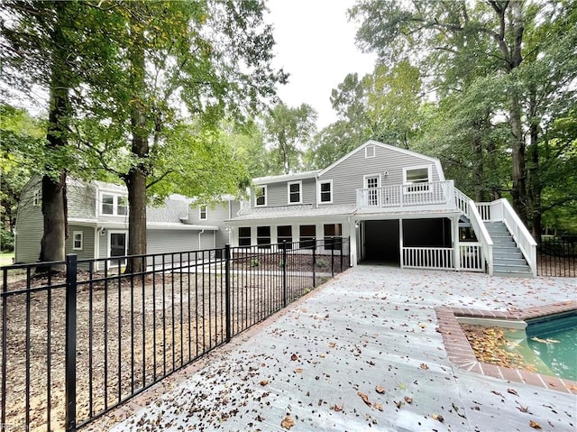 back of property featuring a pool side deck