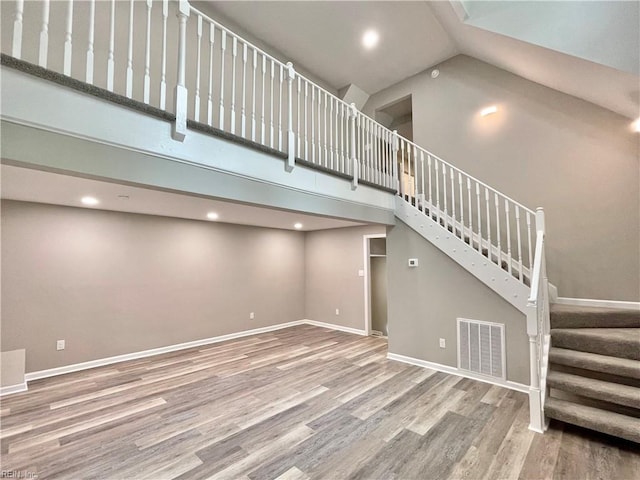 unfurnished living room with hardwood / wood-style flooring and high vaulted ceiling