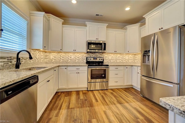 kitchen featuring appliances with stainless steel finishes, crown molding, and white cabinetry