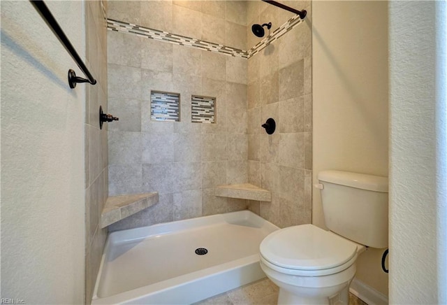 bathroom with toilet and tiled shower