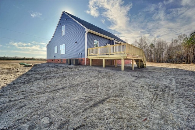 back of property with central AC unit and a wooden deck