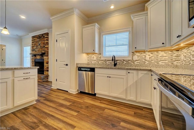 kitchen with white cabinetry, light stone countertops, stainless steel appliances, light wood-type flooring, and decorative light fixtures