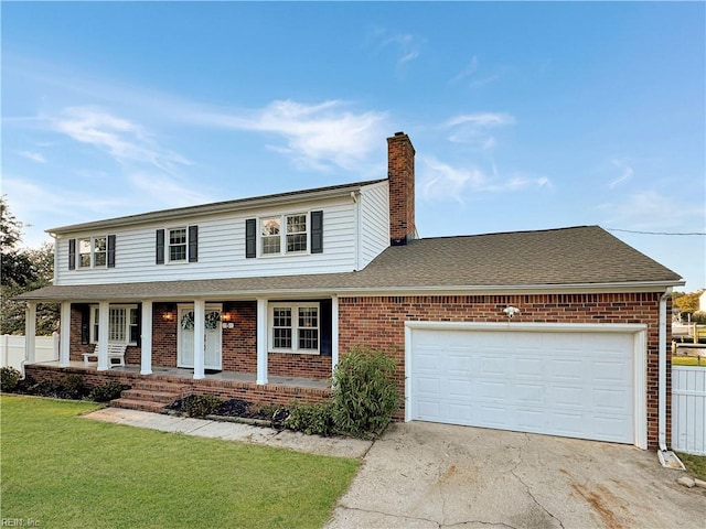 view of front of house with a front lawn, covered porch, and a garage