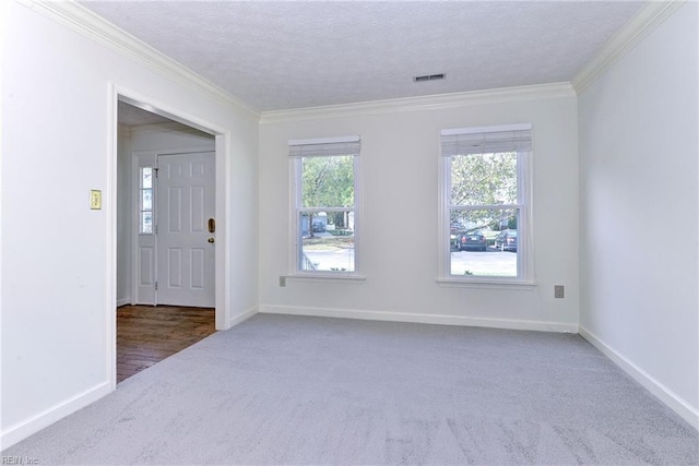 carpeted spare room with a textured ceiling and crown molding