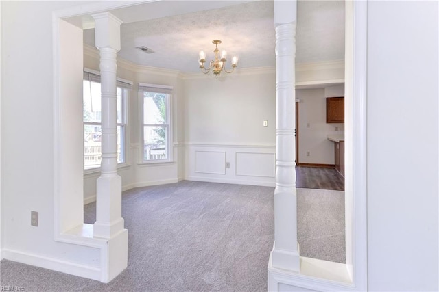 unfurnished room featuring carpet floors, an inviting chandelier, and crown molding