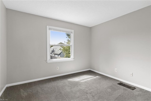 carpeted spare room with a textured ceiling