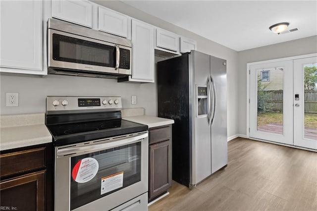 kitchen featuring appliances with stainless steel finishes, light hardwood / wood-style floors, white cabinetry, and dark brown cabinets