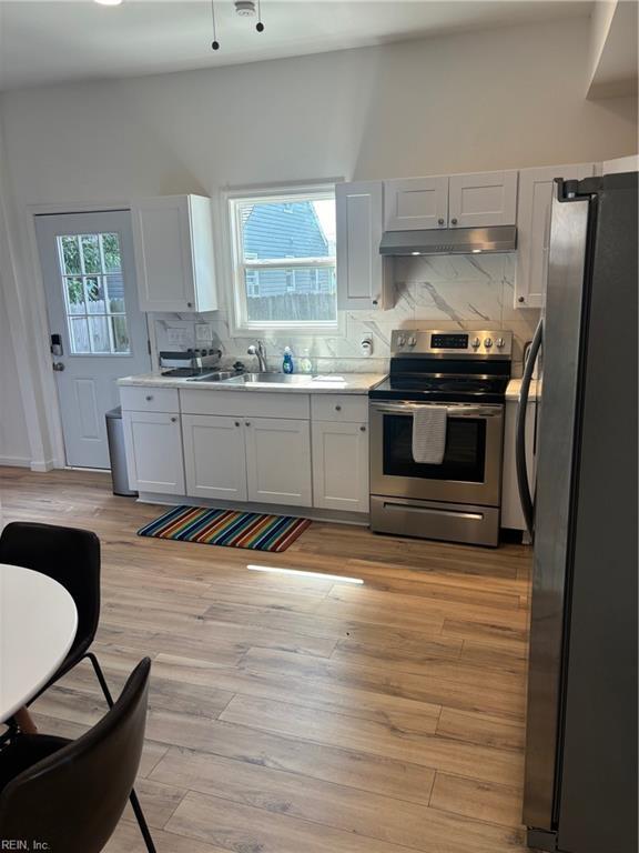 307 N First St, Hampton, VA 23664 - kitchen with stainless steel appliances, a sink, tasteful backsplash, light wood-style floors, and under cabinet range hood