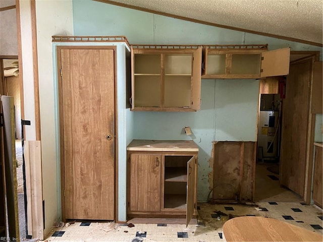 kitchen featuring lofted ceiling, a textured ceiling, and water heater