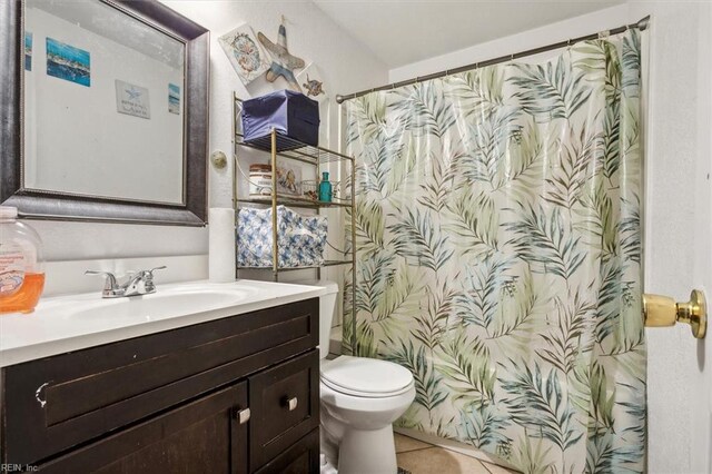 bathroom with tile patterned flooring, a shower with curtain, vanity, and toilet