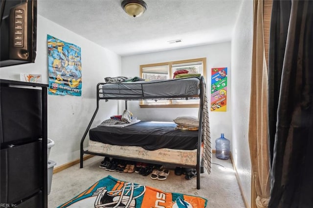 bedroom with a textured ceiling and light colored carpet