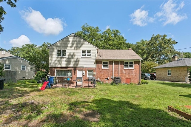 rear view of property featuring a yard and a patio area