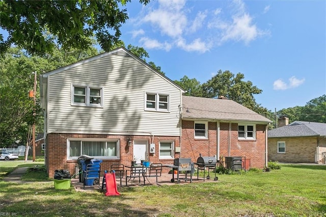 back of property featuring a lawn and a patio area