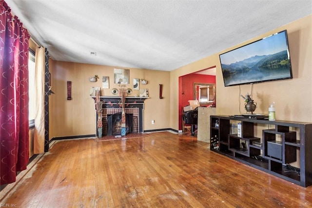 unfurnished living room featuring lofted ceiling, hardwood / wood-style flooring, and a fireplace