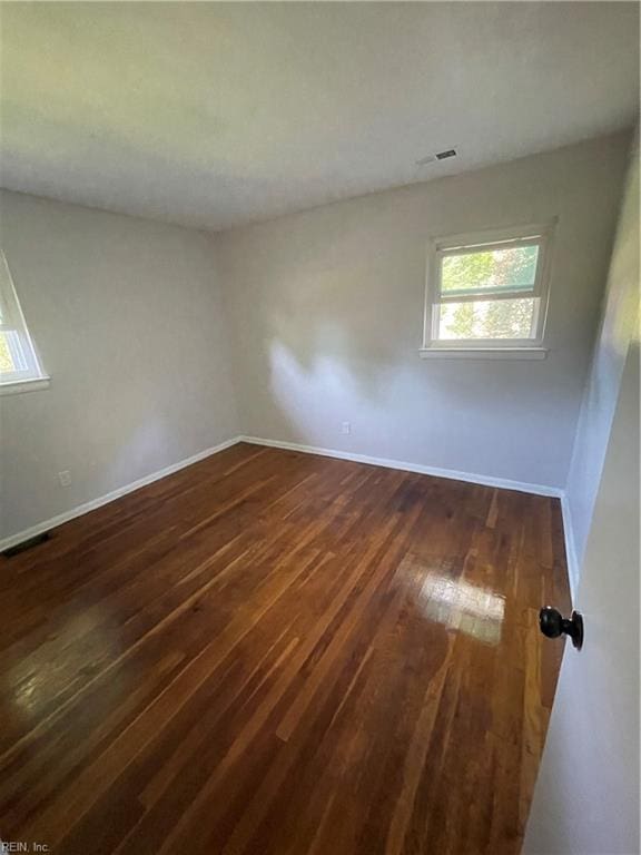 empty room with dark hardwood / wood-style flooring