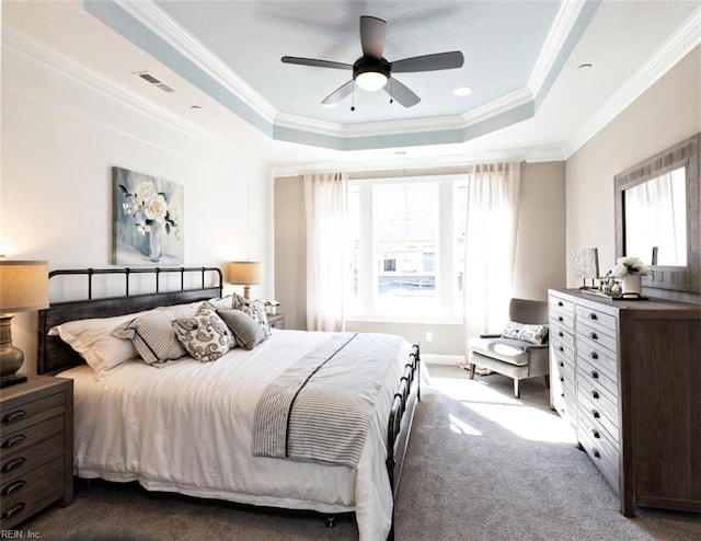 carpeted bedroom featuring ornamental molding, ceiling fan, and a raised ceiling