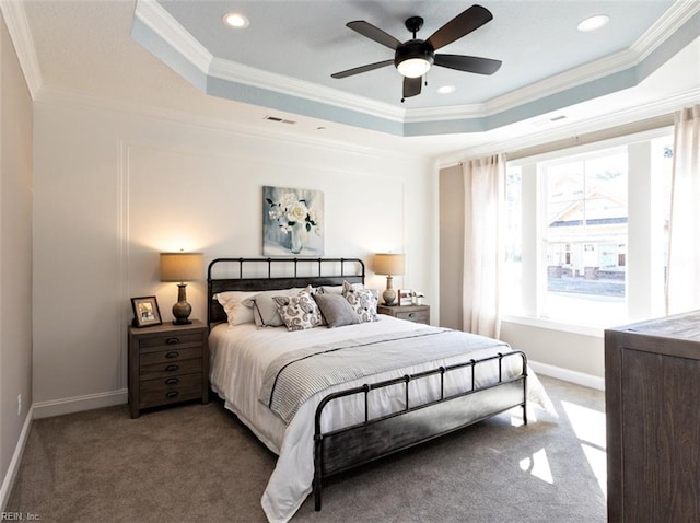 carpeted bedroom featuring ceiling fan, a tray ceiling, and ornamental molding