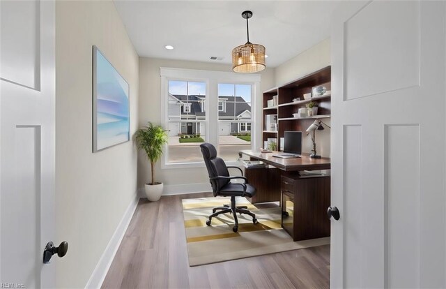 office featuring light hardwood / wood-style flooring and a notable chandelier