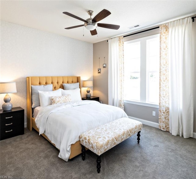 carpeted bedroom featuring multiple windows and ceiling fan