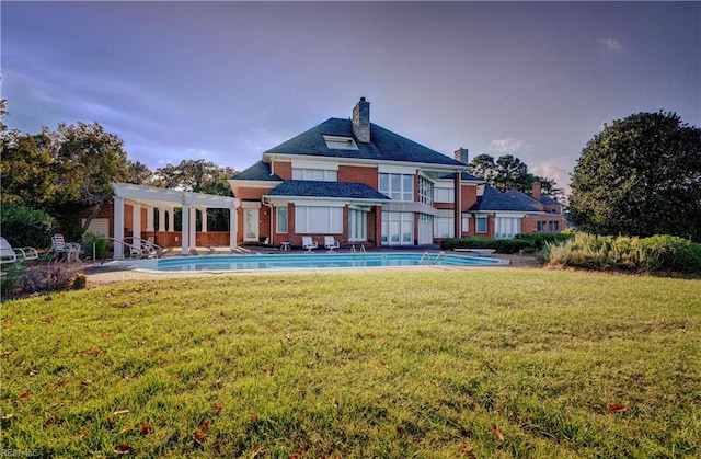 back of house with a pergola, a lawn, and a patio area