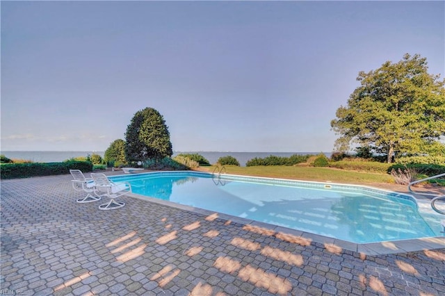 view of pool featuring a patio and a water view