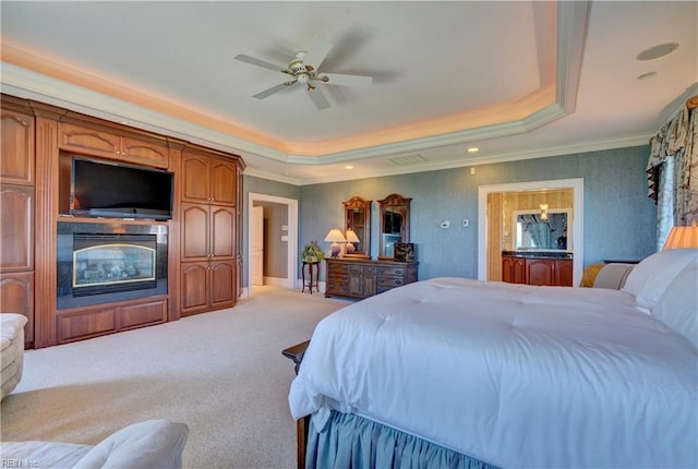 carpeted bedroom featuring ornamental molding, ceiling fan, and a raised ceiling