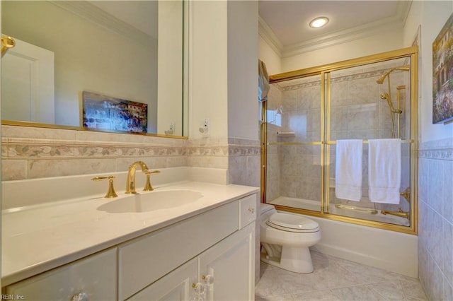 full bathroom with shower / bath combination with glass door, vanity, ornamental molding, tile walls, and toilet