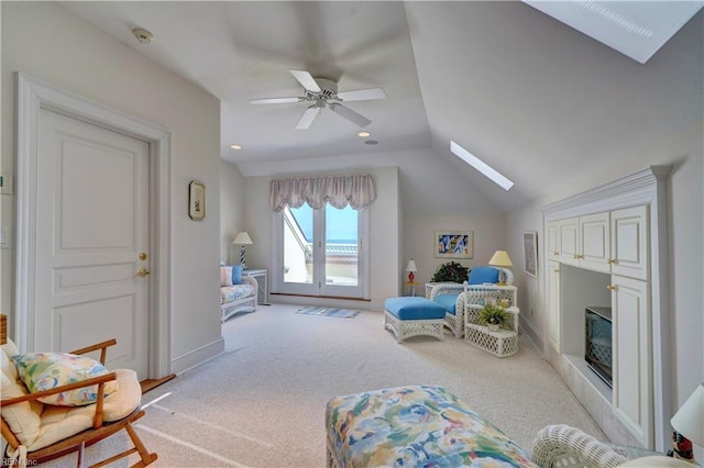 interior space featuring light carpet, ceiling fan, and lofted ceiling with skylight