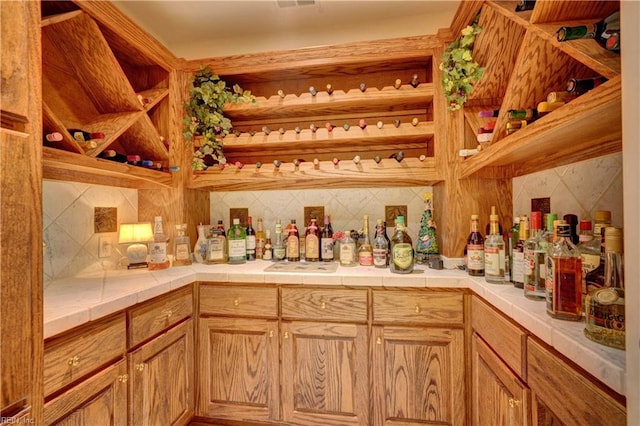 bar with tile countertops and backsplash