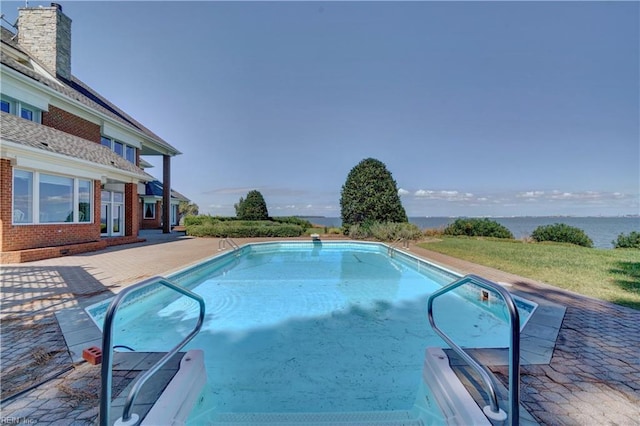 view of swimming pool with a patio and a water view