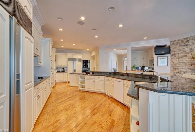 kitchen featuring ornamental molding, kitchen peninsula, white cabinetry, paneled fridge, and light hardwood / wood-style floors