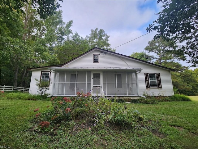 view of front facade with a front lawn and a sunroom