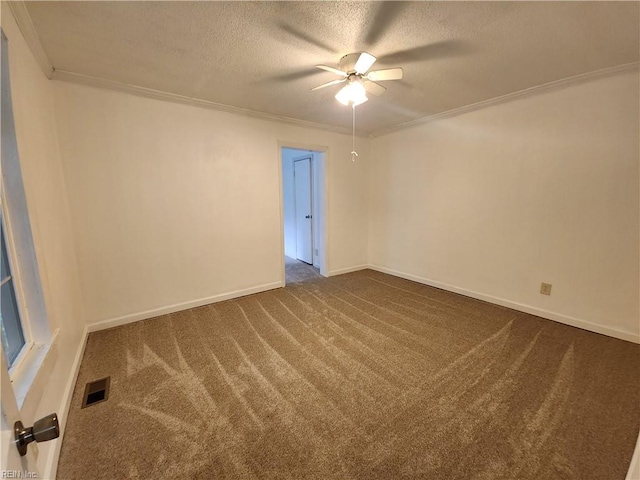 unfurnished room with ceiling fan, a textured ceiling, crown molding, and dark colored carpet