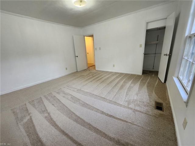 unfurnished bedroom with carpet, ornamental molding, and a closet