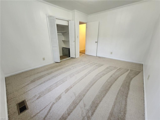 unfurnished bedroom featuring a closet, crown molding, and carpet flooring