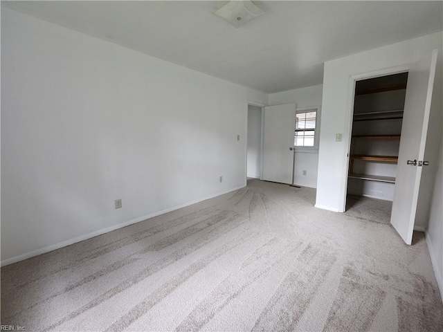 unfurnished bedroom with light colored carpet and a closet