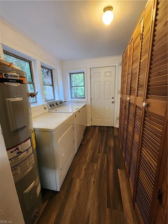 washroom with water heater, separate washer and dryer, and dark wood-type flooring