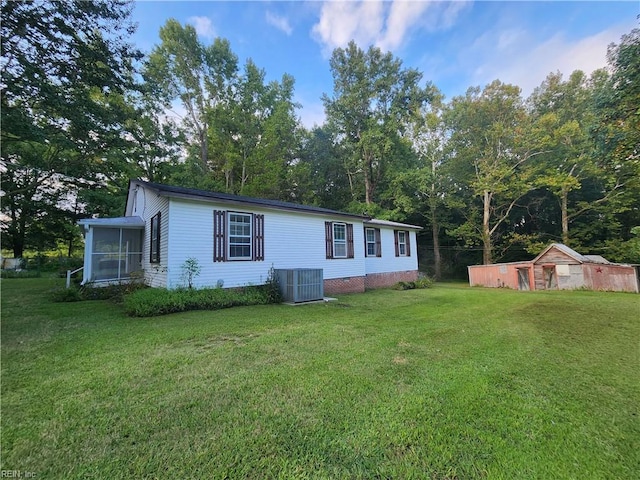 view of front of house with a front lawn and central AC